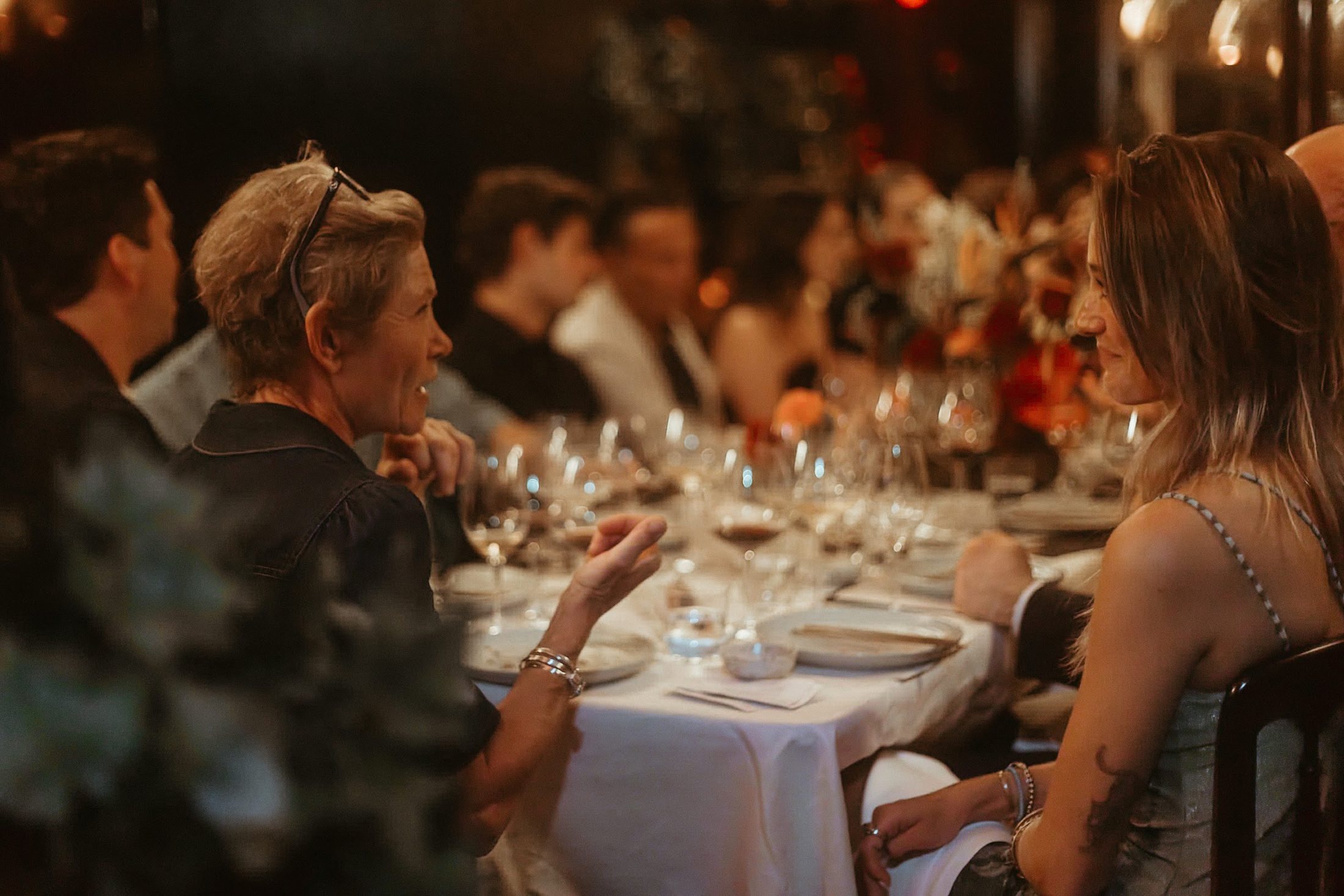 Guests at a long candlelit dinner table